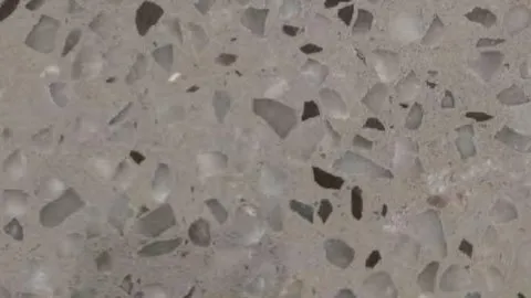 Breccia Grigia engineered marble: warm grey ground crowded with angular smoky grey fragments and black shards