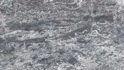 Ocean Star marble: charcoal and blue-grey swirling in horizontal waves through bright white