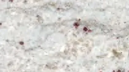 River White granite slab: wavy grey lines on white with a few garnet spots