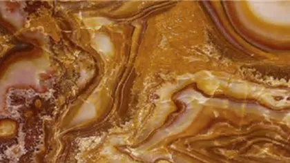 Tiger Onyx slab: swirling chocolate and caramel bands with pale cream eyes