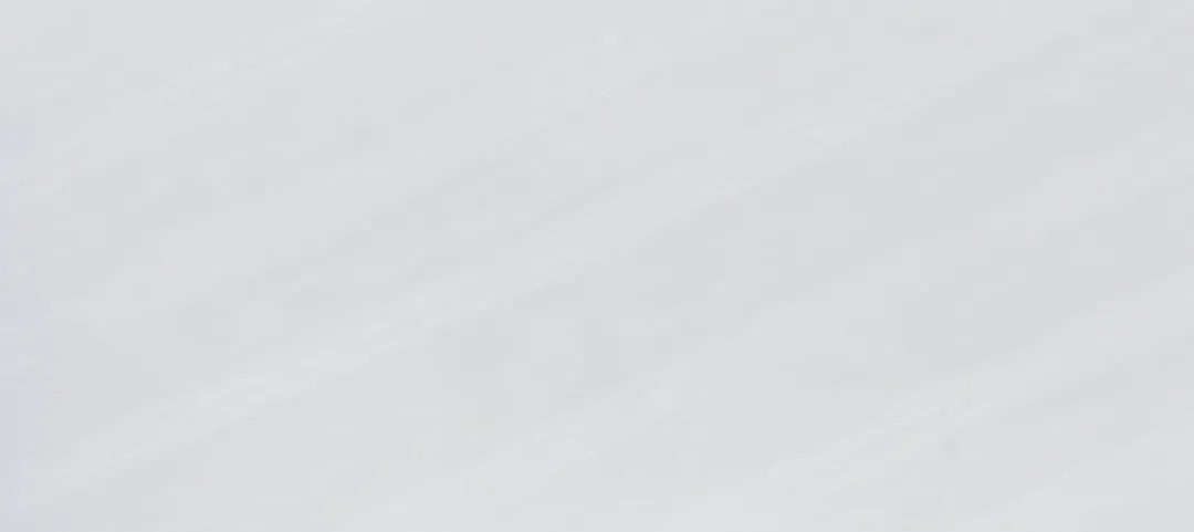 Bianco Nebbia quartz slab: soft white with a misty diagonal drift