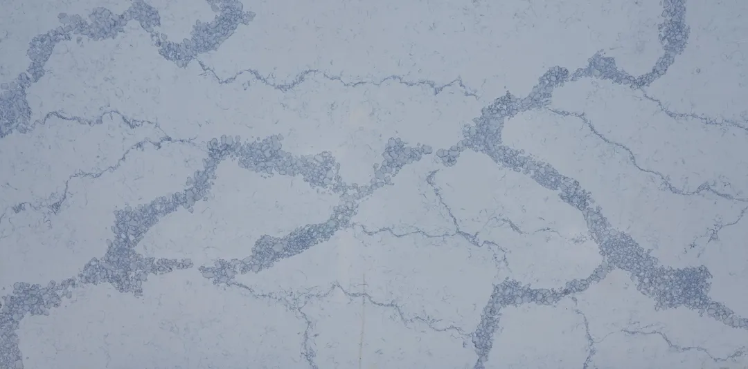 Blu Venato quartz slab: deep blue veins branching across a pale grey-blue ground