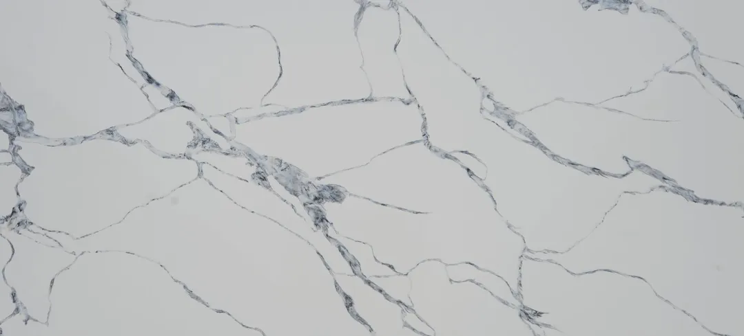 Calacatta Blu quartz slab: branching blue-grey and charcoal veins on white