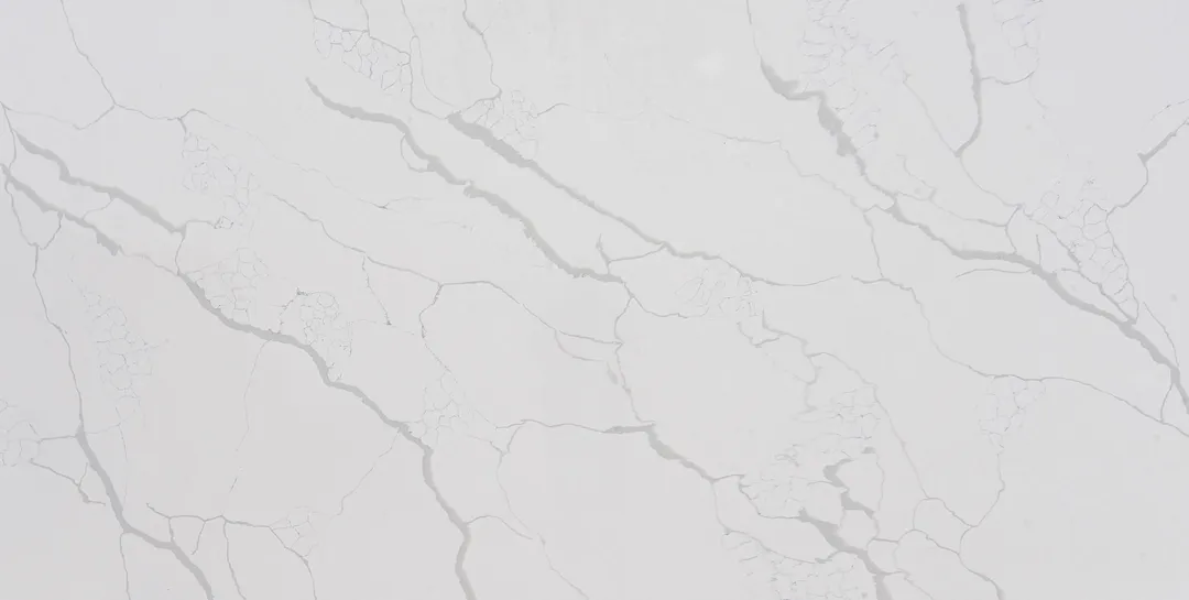 Calacatta Nuvola quartz slab: hazy grey veins and cloudy patches drifting diagonally on white