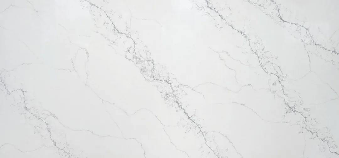 Calacatta Seta quartz slab: faint grey veins with fine flecked clusters on white