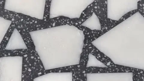 Palladiana terrazzo: irregular white marble pieces set in charcoal terrazzo joints flecked with white